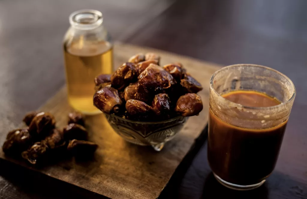 Dattes entières accompagnées de sirop de dattes, utilisées comme alternative naturelle au sucre blanc.