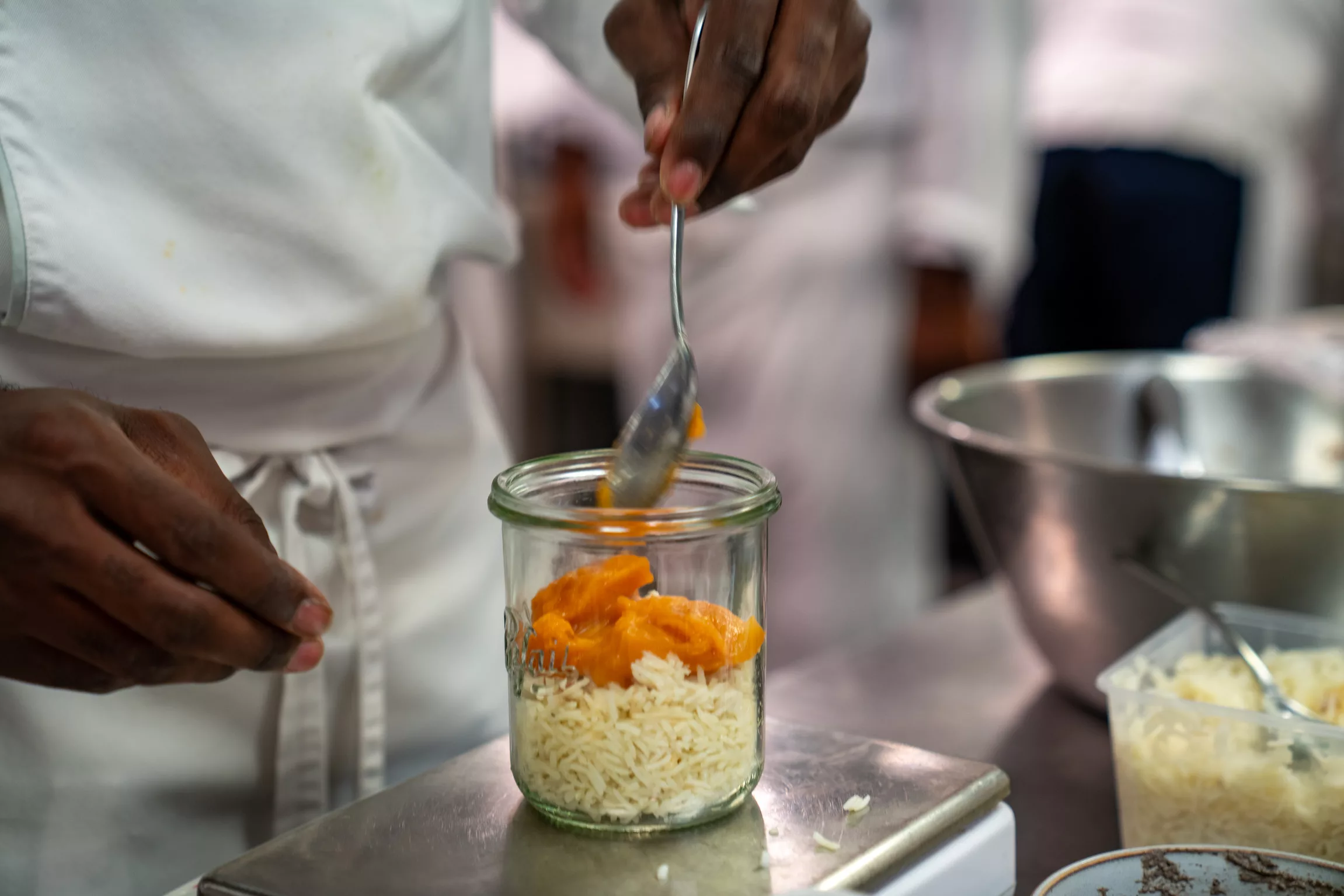 Dressage d'un plateau repas en bocal par un cuisinier de Fika Traiteur, traiteur inclusif à Paris